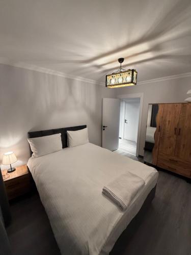 a bedroom with a large white bed and a chandelier at Twelve Diamond Hotel in Istanbul