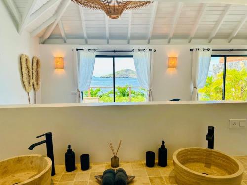 a bathroom with two sinks and a large window at Case Macalpa in Saint Barthelemy