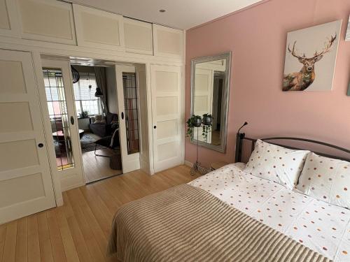a bedroom with a bed with a deer picture on the wall at Sfeervol appartement met tuin bij centrum & station in Dordrecht