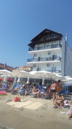 a group of people sitting in the sand at the beach at Nepheli in Paralia Katerinis