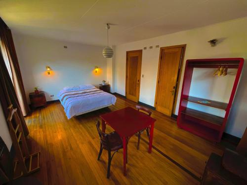 a bedroom with a bed and a table in it at Hostel Hotzenplotz Alegre in Valparaíso
