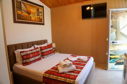 a bedroom with a bed with towels on it at Lake Bliss Cabins in Shkodër