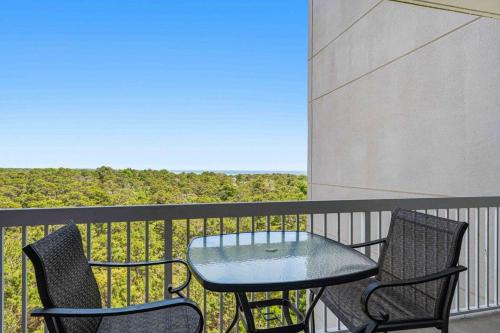 a table and two chairs on a balcony with a view at Easy Beach Walk Pools and Hot Tubs in Destin