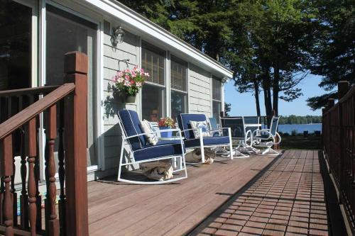 a deck with chairs and a cat laying on it at Sebago Waterfront Escape with Private Dock in Windham
