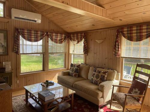 a living room with a couch and a table at Sebago Waterfront Escape with Private Dock in Windham