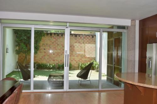 a kitchen with sliding glass doors with a table and chairs at Valentin House, very spacious and cozy. in San Luis Potosí
