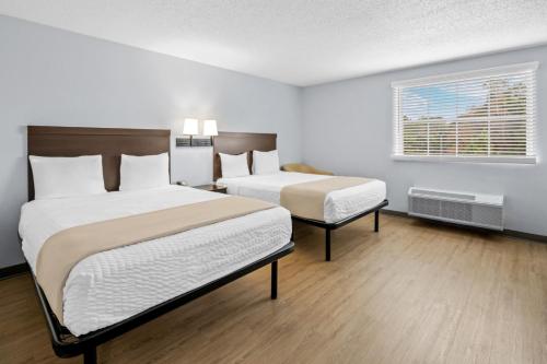 a hotel room with two beds and a window at Suburban Studios Near Camp Lejeune in Jacksonville