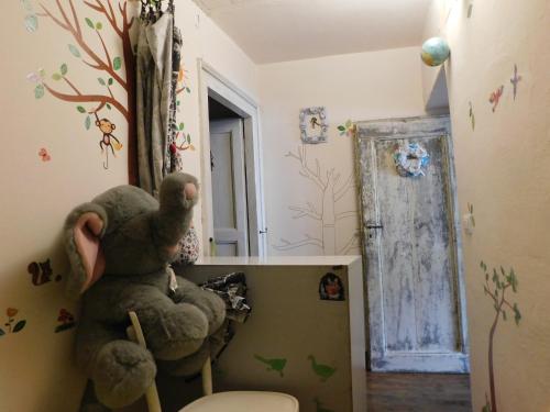a bathroom with a stuffed animal sitting on a toilet at Gioco dell'oca in Ponna Superiore