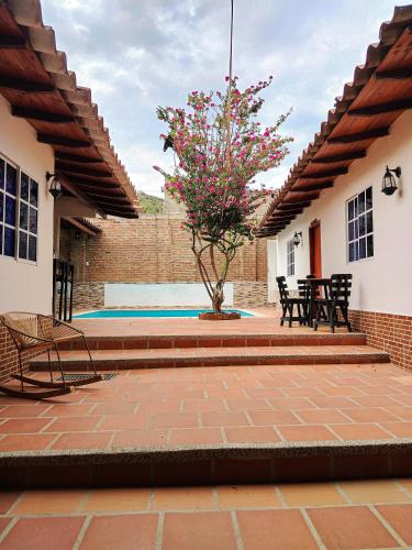 a patio with a tree and a table and chairs at Casalajud Wellness in Taganga