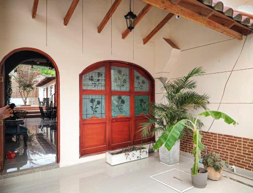 a red door of a house with a potted plant at Casalajud Wellness in Taganga