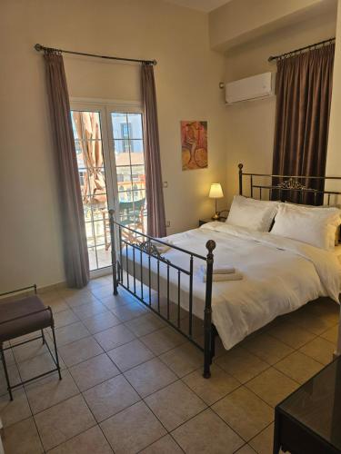 a bedroom with a large bed and a balcony at Amfitrion on the Town in Gythio