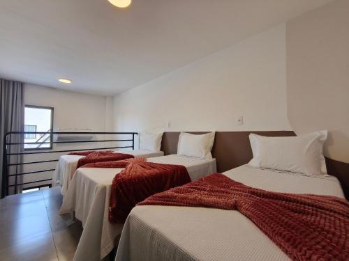 three beds in a room with a balcony at One Studios Indaiatuba in Indaiatuba