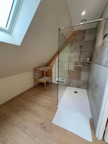 a bathroom with a glass shower in a attic at La Parenthèse in Le Plouy