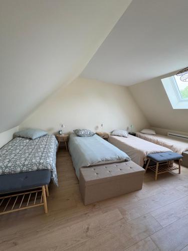 a attic bedroom with two beds and a window at La Parenthèse in Le Plouy