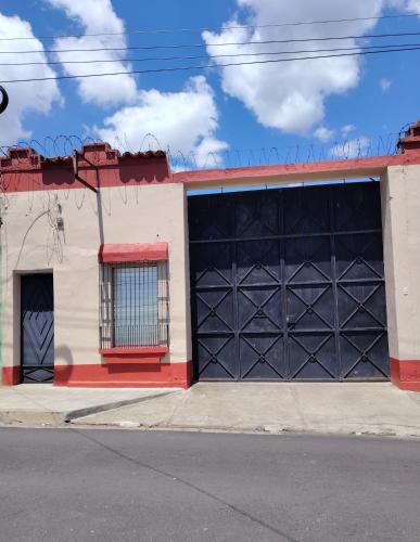 a building with a black garage door on a street at Beto's house in Santa Ana