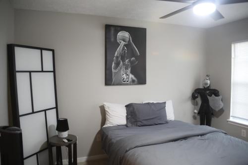 a bedroom with a bed and a skeleton picture on the wall at #HycheHoops Final Four Nest in Starkville