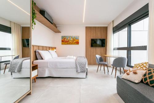 a bedroom with a bed and a table and chairs at Modern Studio | Pool | Gym #SG10 in Florianópolis