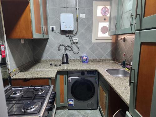 a small kitchen with a washing machine in the counters at Modern 3-BR gated Sheikh Zayed Compound Open Views in Sheikh Zayed