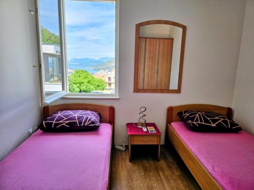 two beds in a room with a mirror and a table at Guest House Banana in Dubrovnik