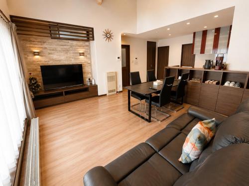 a living room with a couch and a table at House Villa Koharu in Asahikawa