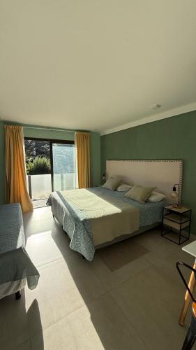 a bedroom with a large bed and a large window at Terracampo Apart in Ciudad Lujan de Cuyo