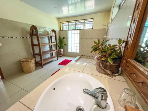 a bathroom with a tub and a sink at Fare Faaroa Lodge in Taputapuapea