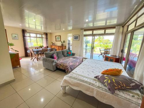 a living room with a bed and a couch at Fare Faaroa Lodge in Taputapuapea