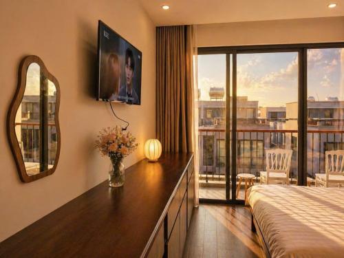 a bedroom with a bed and a view of a balcony at Bareka Hotel in Phú Quốc