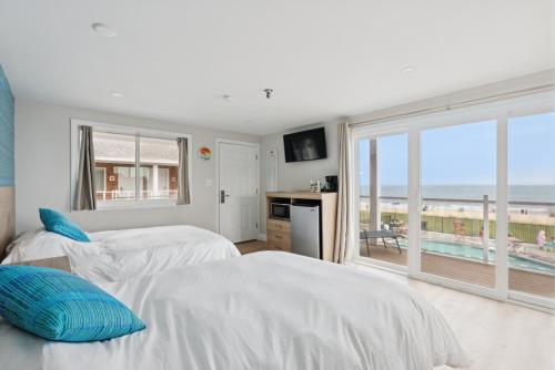 two beds in a bedroom with a view of the beach at The Voyager in Old Orchard Beach