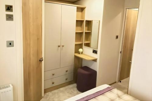 a bedroom with a bed and a desk and a mirror at Spacious Caravan - Durdle Door Holiday Park in West Lulworth