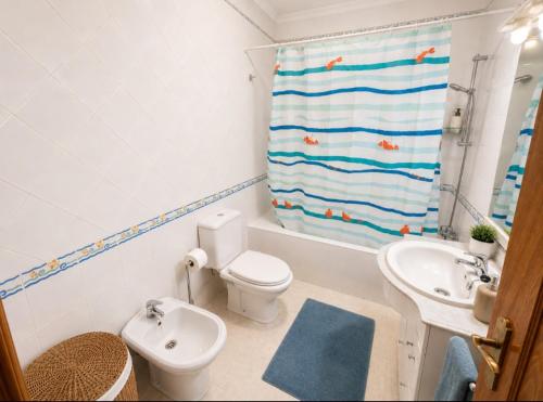 a bathroom with a toilet and a sink and a shower curtain at Apartamento Sunrise in Altura