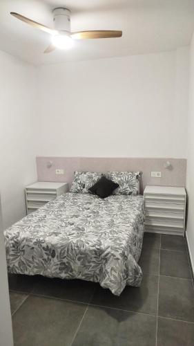 a bedroom with a bed with a comforter on it at Loresti Mare in Fuengirola
