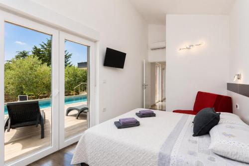 a bedroom with a bed and a balcony with a pool at Villa LM in Krnica