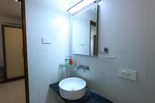 a bathroom with a white toilet and a mirror at MB hotel in Rajkot