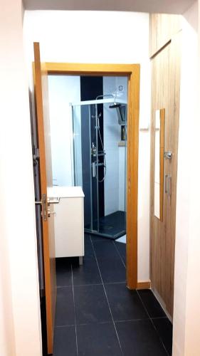 a bathroom with a shower and a glass door at Vista Central Amadora in Amadora