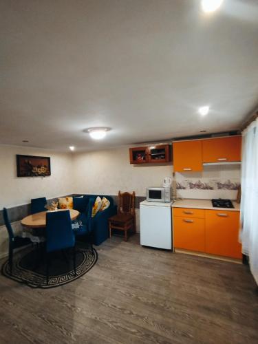 a kitchen and a living room with a table and chairs at Лісова казка in Yaremche
