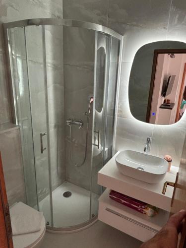 a bathroom with a shower and a sink at Meri apartmani in Promajna