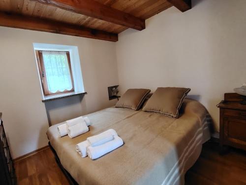 a bedroom with a large bed with two towels on it at Casa Allegra in Pont-Saint-Martin