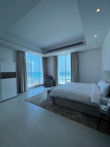 a bedroom with a bed and a view of the ocean at شاليهات الجوهرة in Fins