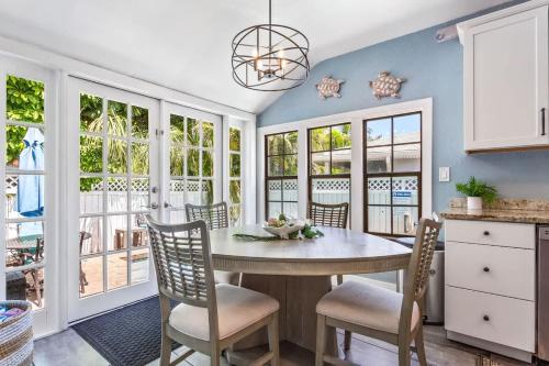 a dining room with a table and chairs and windows at Coconut Beach House in Clearwater Beach