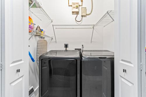 a laundry room with two washer and dryer at Sunset Villa w Pool, Outdoor kitchen & Grill in Hialeah