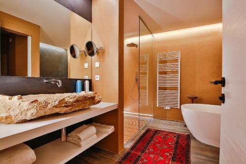 a bathroom with a tub and a sink at Adler Suite & Stube in Villabassa