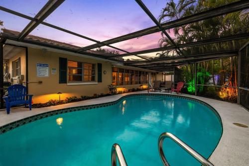 a swimming pool with a pergola and a house at Sunset Beach House in Clearwater Beach