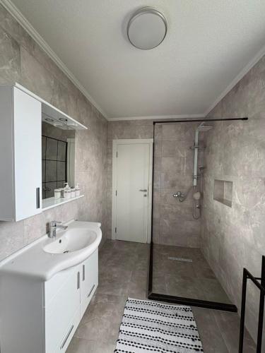 a bathroom with a white sink and a shower at Vila Ziki in Sarajevo
