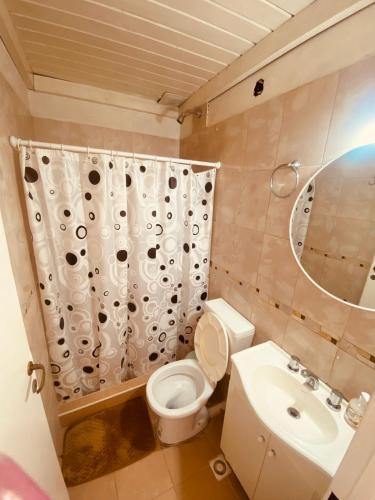 a bathroom with a toilet and a sink and a mirror at MG Suites in Monte Grande