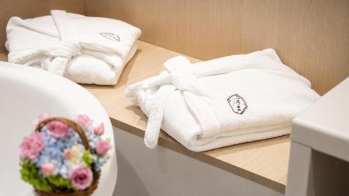 two towels on a counter with a basket of flowers at Hotel Punto MX in Mexico City