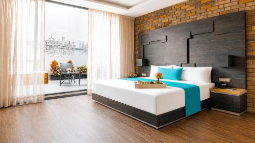 a bedroom with a large bed with a brick wall at Hotel Punto MX in Mexico City