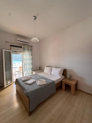a bedroom with a bed and a table and a window at Sea View Studios, Harbour Beach, Bali in Bali
