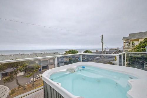 a hot tub on a balcony with a view of the beach at Harbor SeaShell in Lincoln City