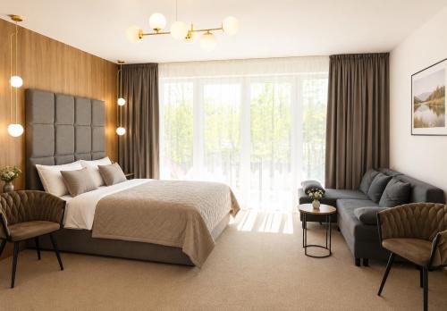 a bedroom with a bed and a couch at Eden Apartament-Jacuzzi, sauna in Jastrzębia Góra